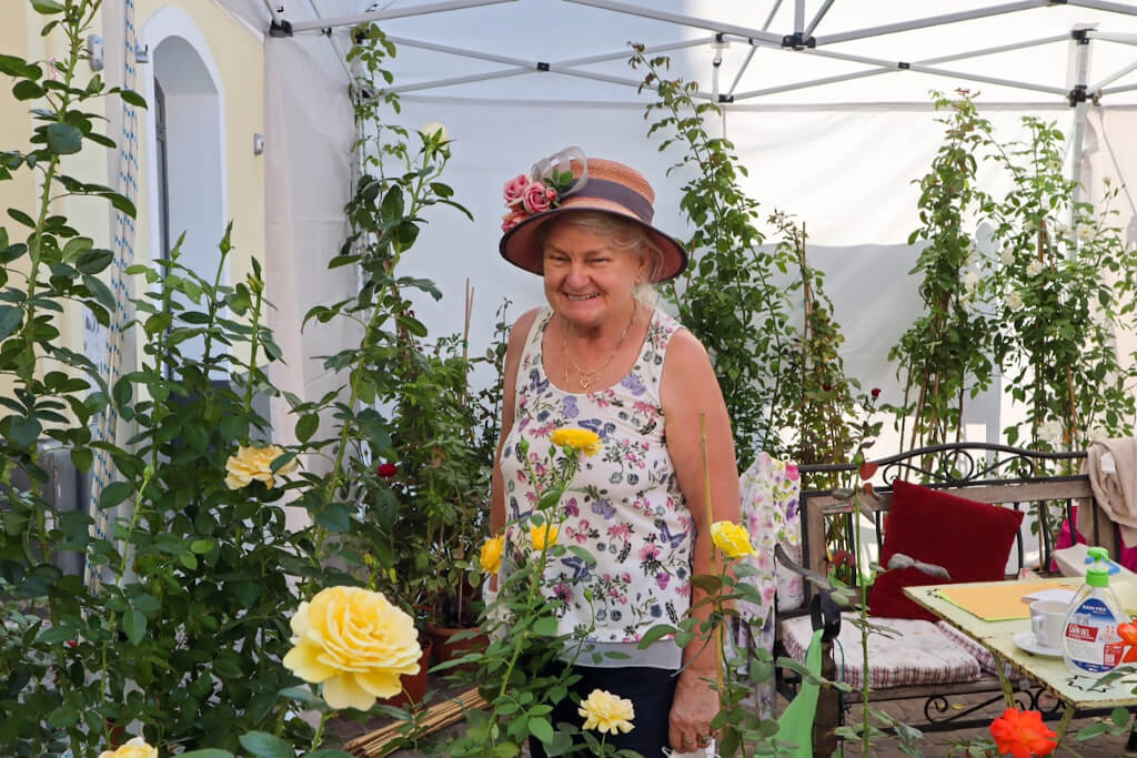 Una simpatica signora nel suo stand di rose ad Aromatica